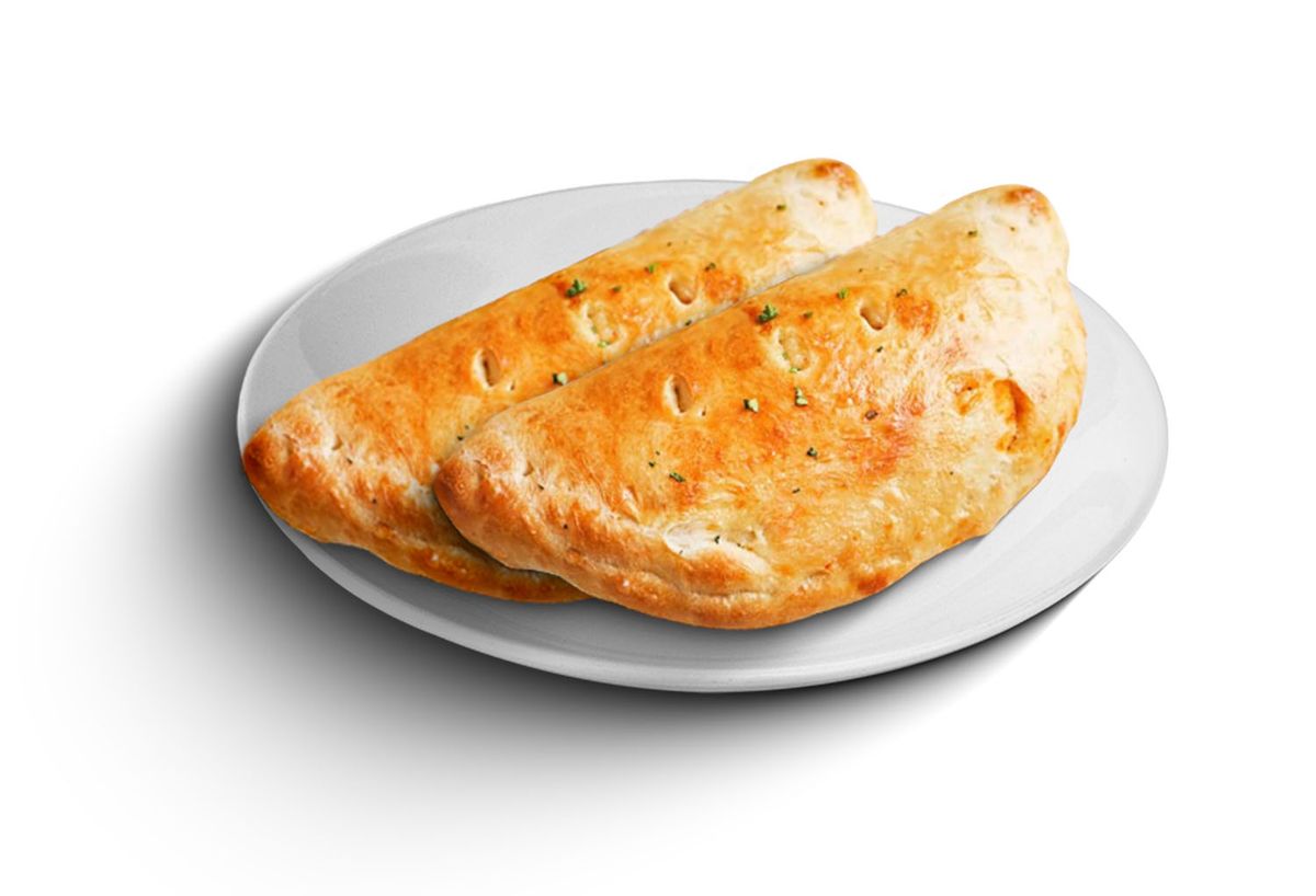 A golden-brown baked calzone served on a plate, illustrating a blog about Indian-style calzones available in Torrance.