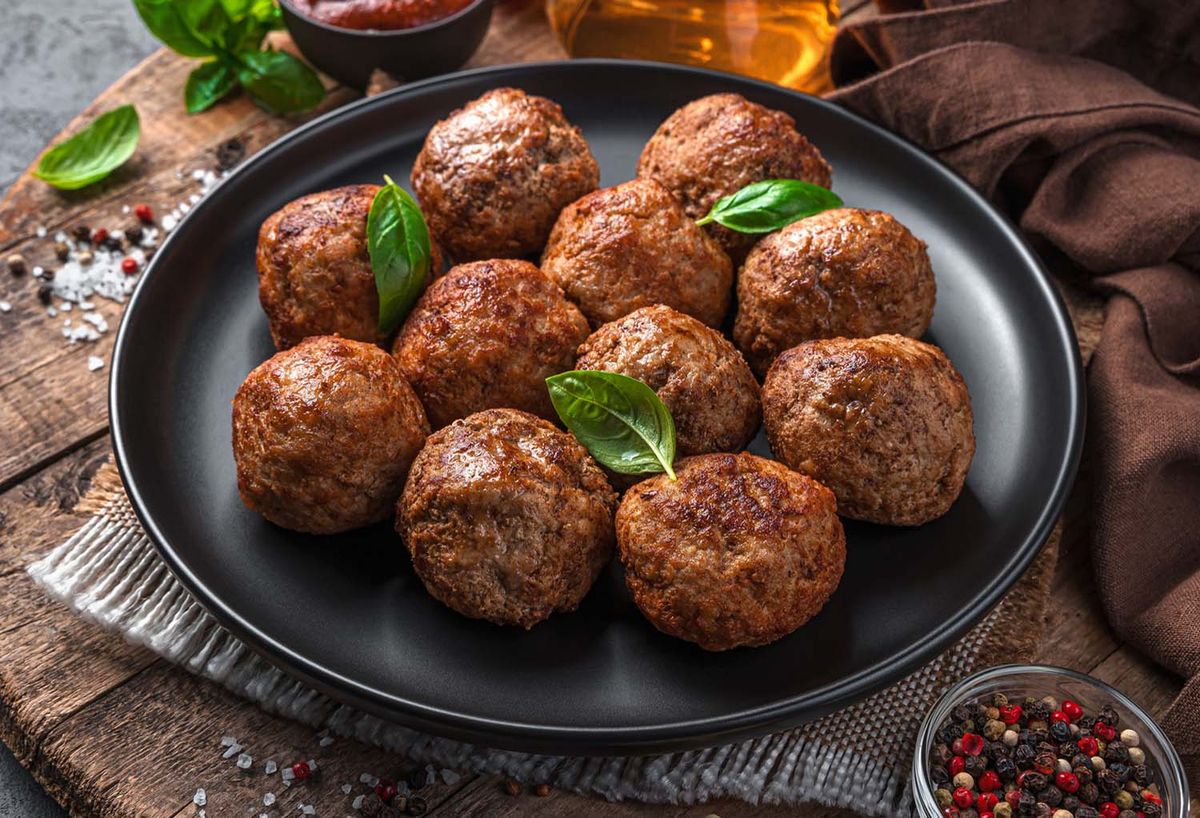 A serving of seasoned meat toppings or meat-based dish, representing a blog about customizing non-vegetarian pizzas with various toppings.