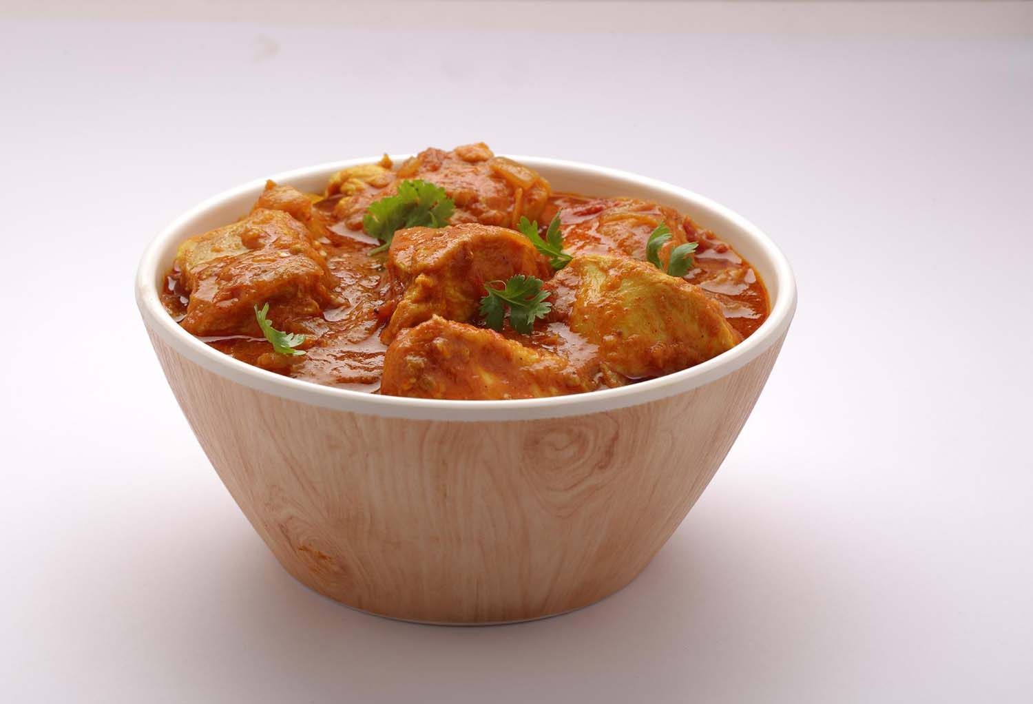 A bowl of rich chicken curry with boneless pieces in a spiced gravy, representing a blog about popular non-vegetarian curry dishes.